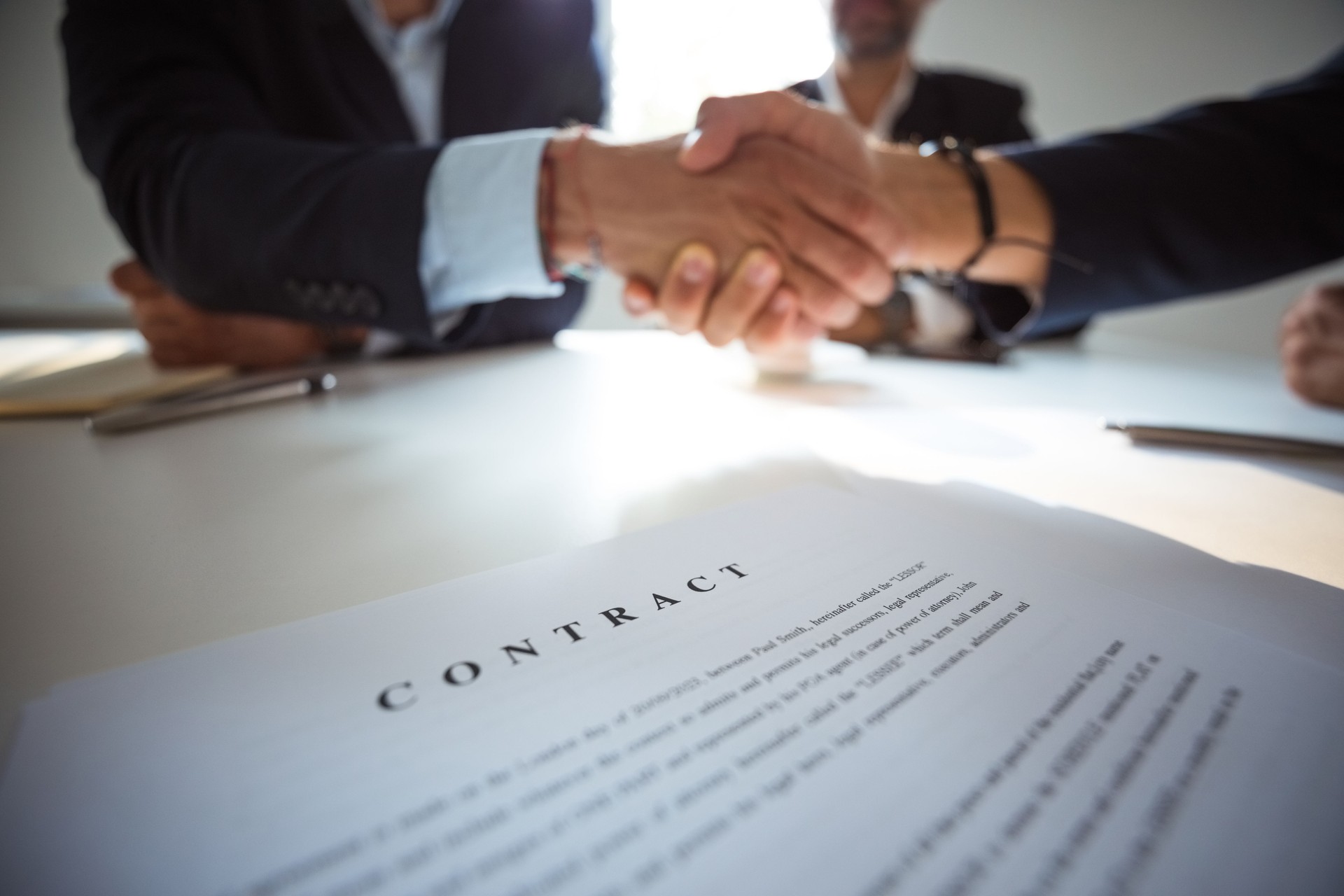 Businessmen shaking hands over contract